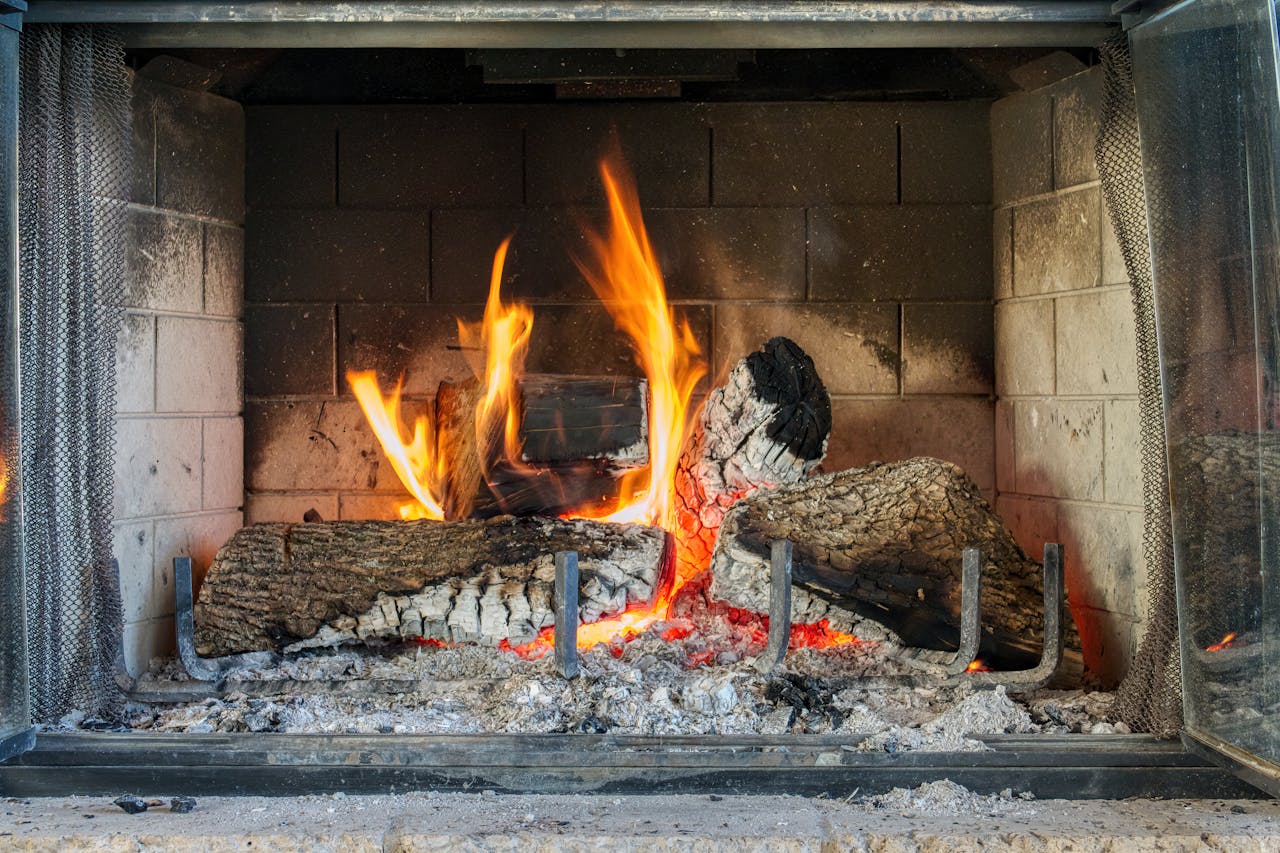 Warm and inviting indoor fireplace with glowing firewood and vibrant flames.