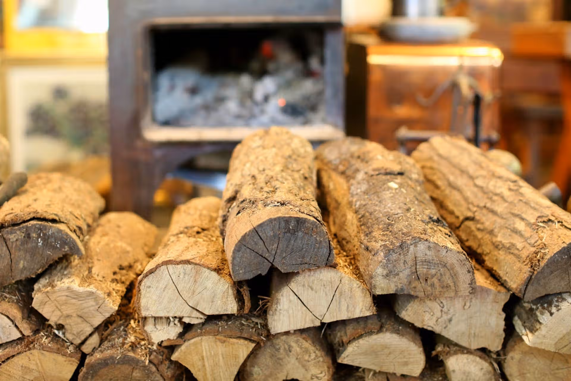 A rustic stack of firewood in front of a cozy indoor fireplace, creating a warm ambiance.