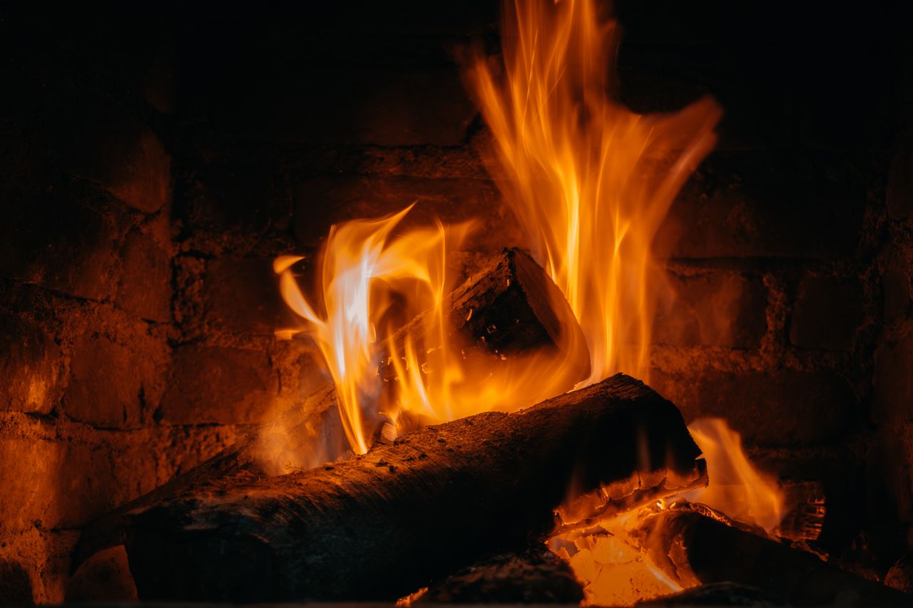 A detailed view of warm flames in a cozy indoor fireplace setting.